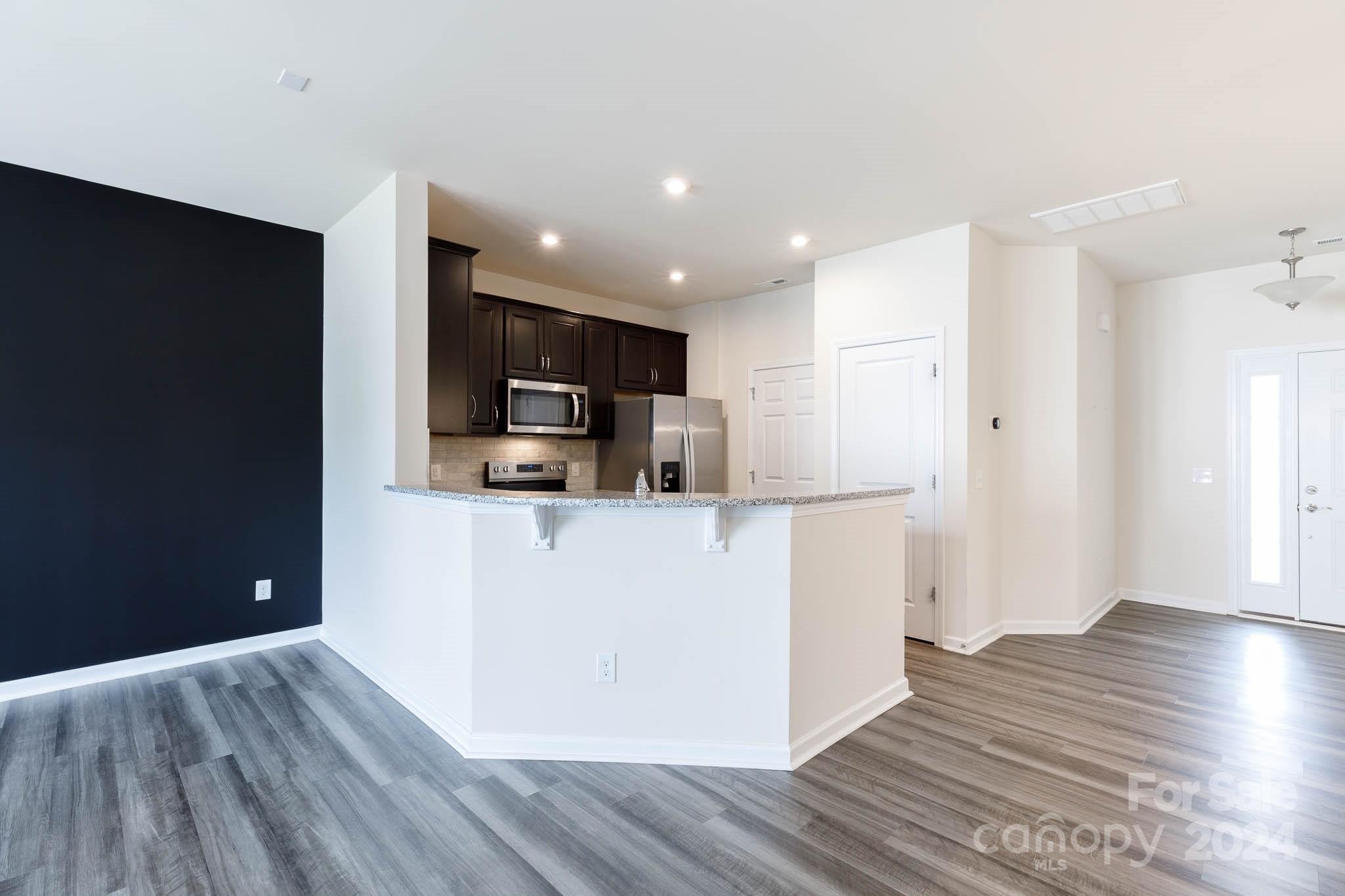 813 Canoe Song Road Fort Mill, SC 29708 - Photo 5 of 26 a view of kitchen with stainless steel appliances granite countertop a refrigerator a sink dishwasher and a stove with wooden floor