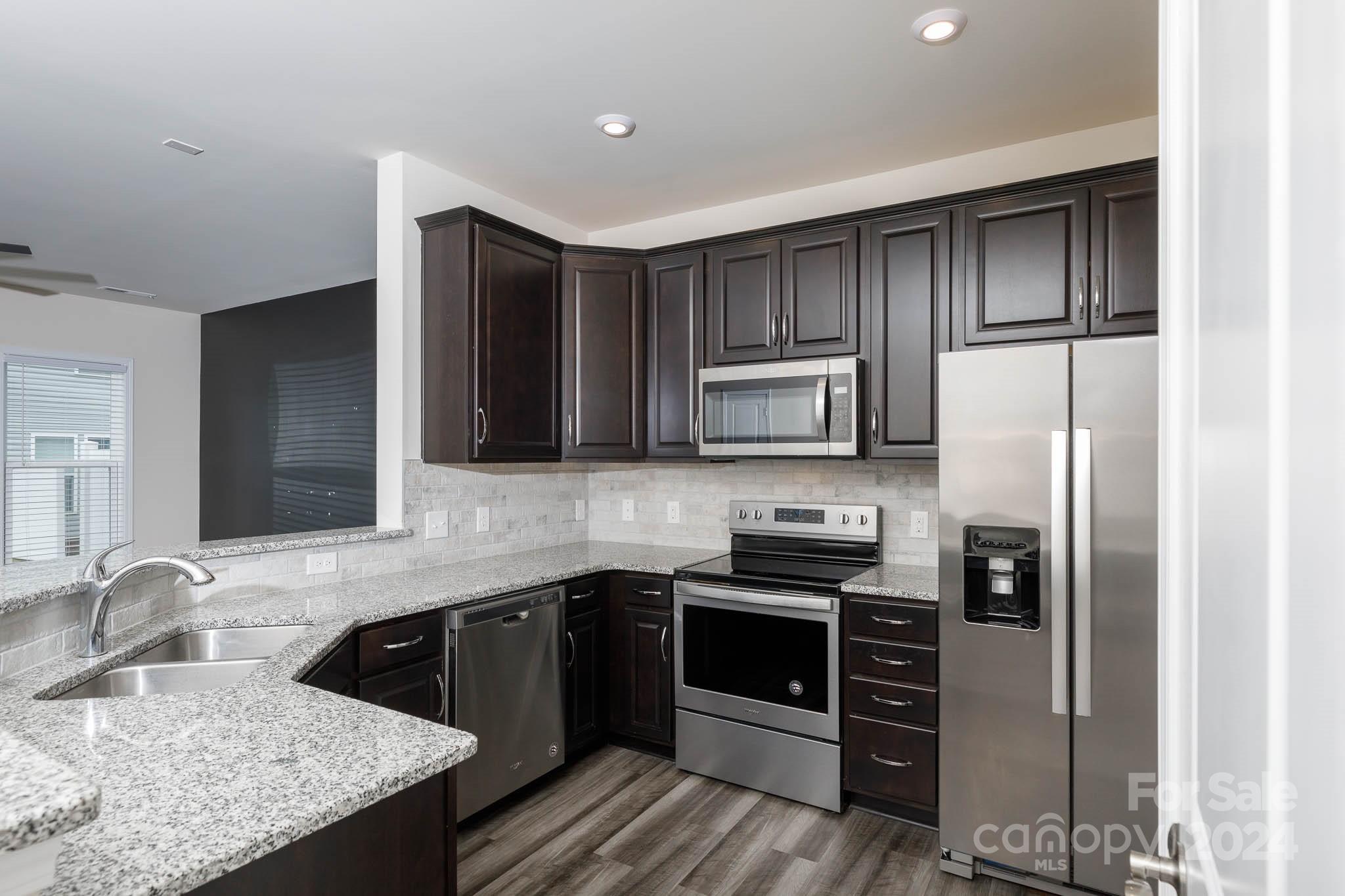813 Canoe Song Road Fort Mill, SC 29708 - Photo 8 of 26 a kitchen with stainless steel appliances granite countertop a sink stove and refrigerator