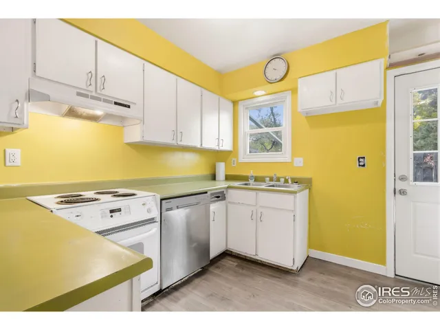 a kitchen with granite countertop a sink a stove and cabinets