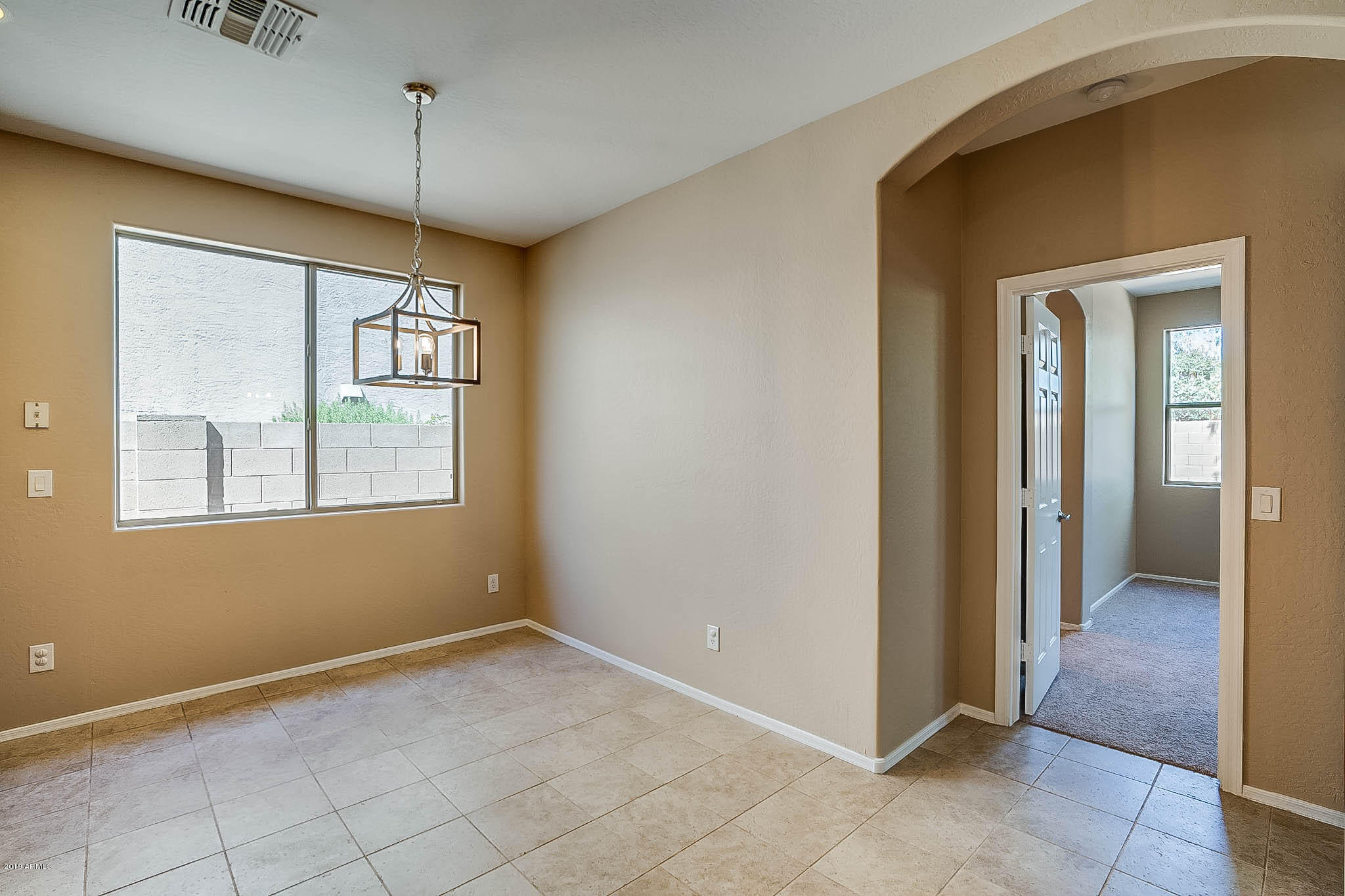 8754 West Payson Road Tolleson, AZ 85353 - Photo 7 of 19 a view of an empty room with window and chandelier fan
