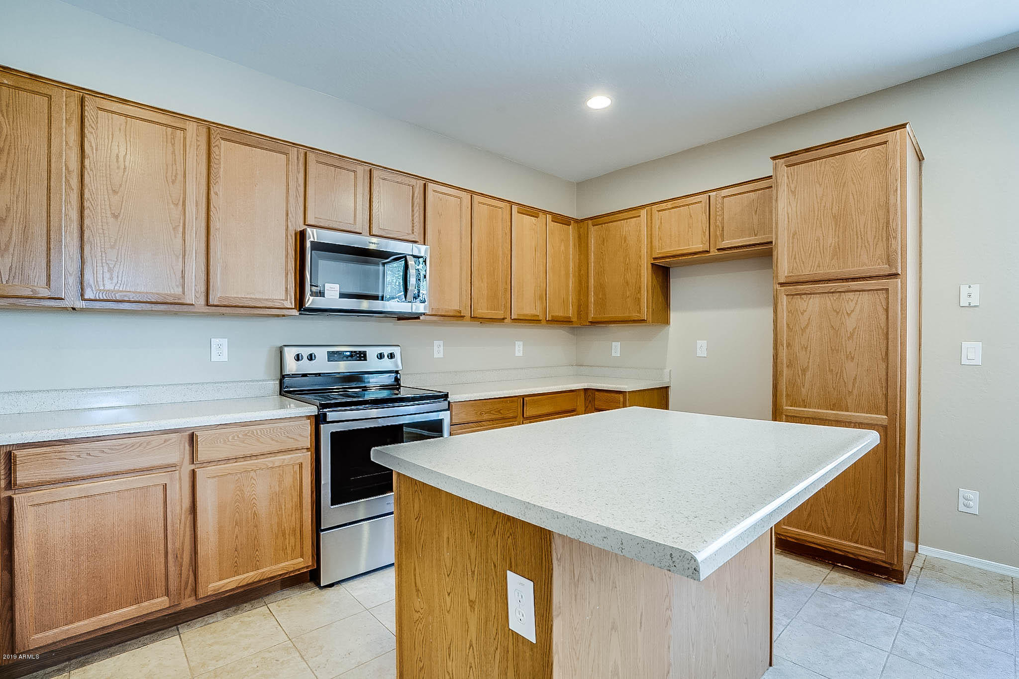 8754 West Payson Road Tolleson, AZ 85353 - Photo 8 of 19 a kitchen with a sink a microwave a stove and refrigerator
