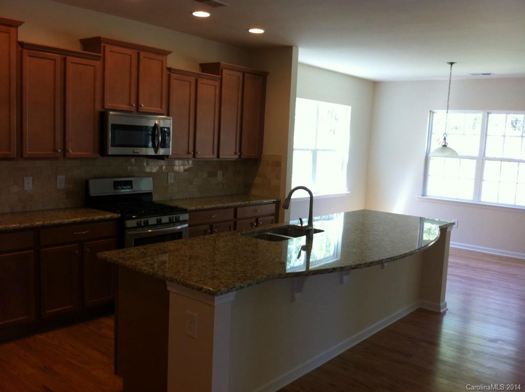 4117 Perth Road, Unit 374 Indian Land, SC 29707 - Photo 5 of 13 a kitchen with kitchen island granite countertop a sink a counter top space appliances and cabinets