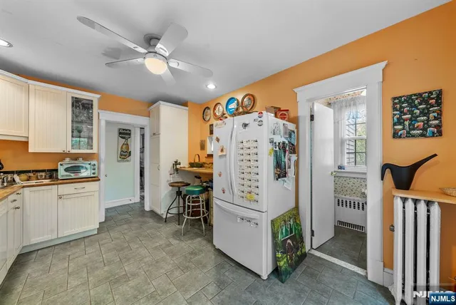 a kitchen that has a lot of cabinets stainless steel appliances and a chandelier