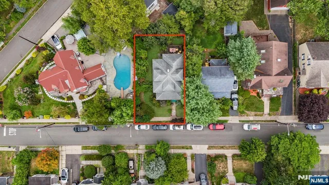 an aerial view of residential houses with outdoor space and trees