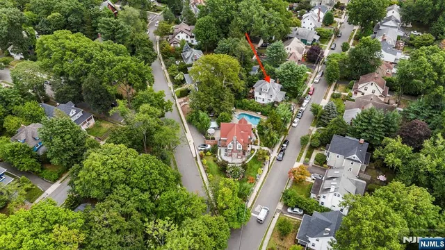 an aerial view of residential houses with outdoor space and trees all around