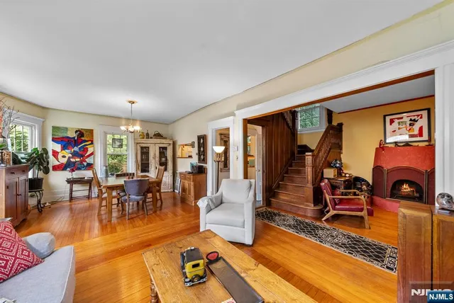 a living room with furniture a dining table and chairs with floor to ceiling window