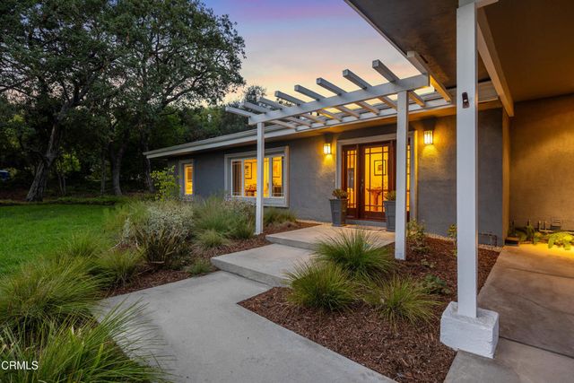 a view of a porch with plants and trees