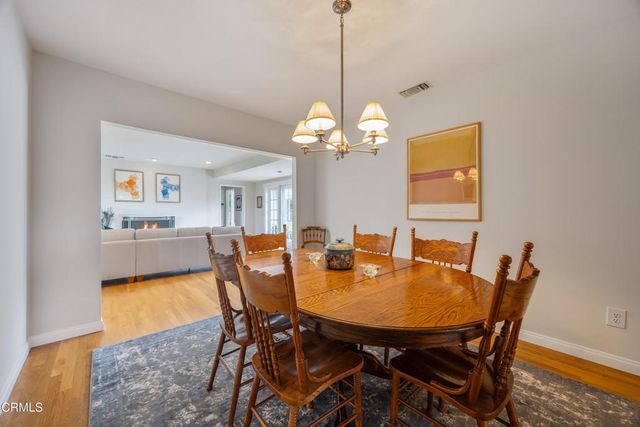 a kitchen with stainless steel appliances a stove a refrigerator and a dining table
