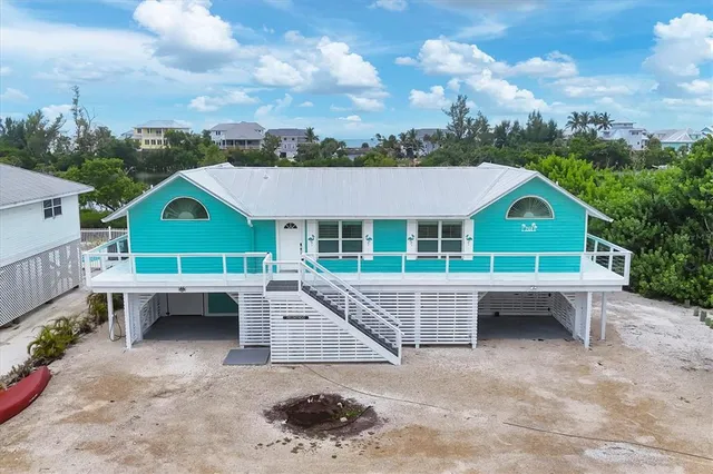 an aerial view of a house with a swimming pool and outdoor seating