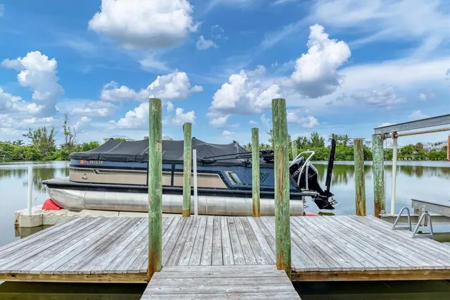 a view of a balcony with dining table and chairs with wooden floor and fence