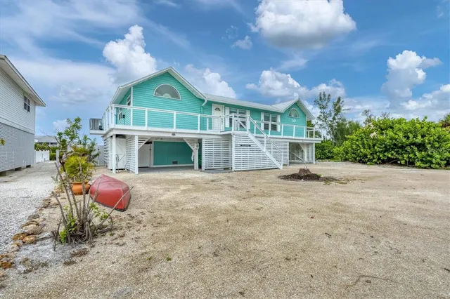 a view of yellow house with large windows and a table
