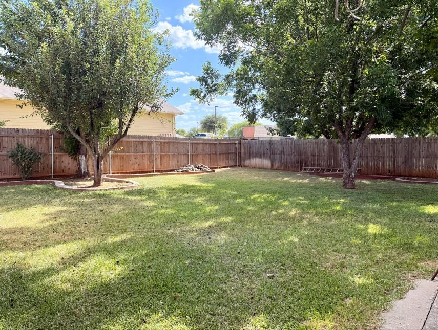 2604 Crix Lane Fort Worth, TX 76140 - Photo 13 of 13 Spacious backyard featuring a full perimeter wood fence, two mature trees, and an expansive lawn area