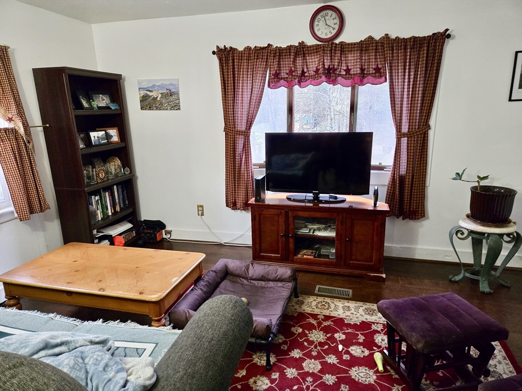 29 Finn Park Road Rutland, MA 01543 - Photo 3 of 24 a living room with furniture a flat screen tv and a floor to ceiling window