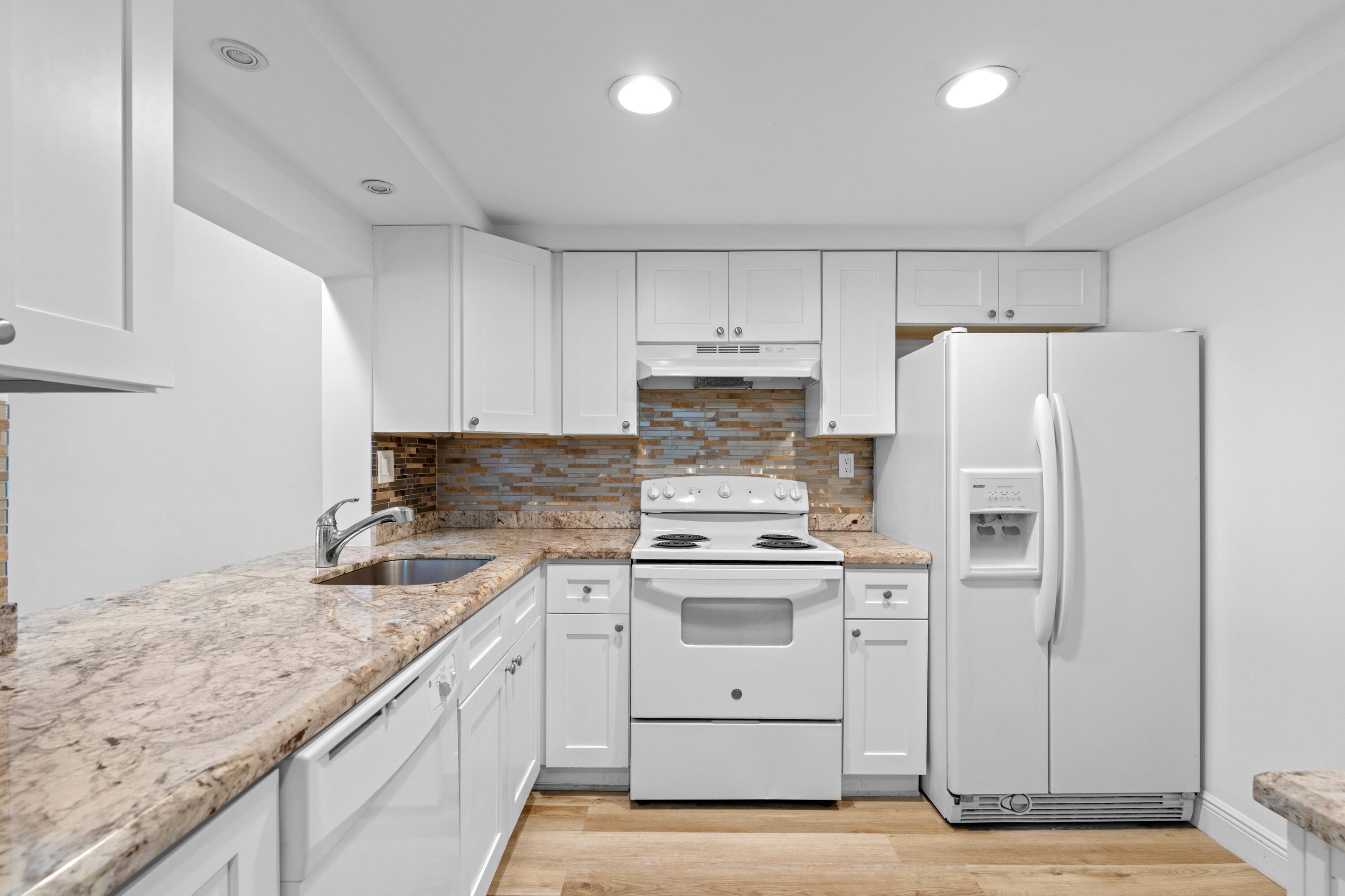 3710 North Pine Island Road, Unit 114 Sunrise, FL 33351 - Photo 7 of 32 a kitchen with a sink a stove a refrigerator and white cabinets