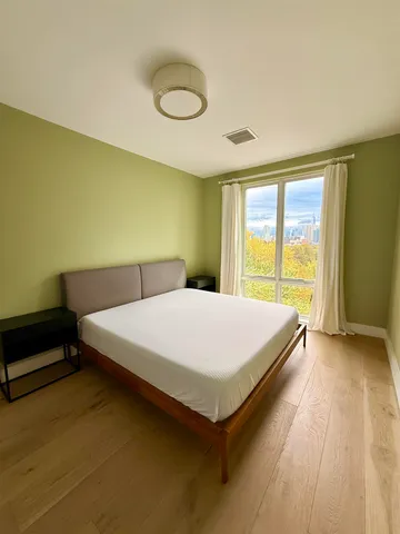 a bed sitting in a bedroom next to a window