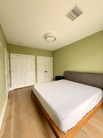 a spacious bedroom with a bed and a cabinets