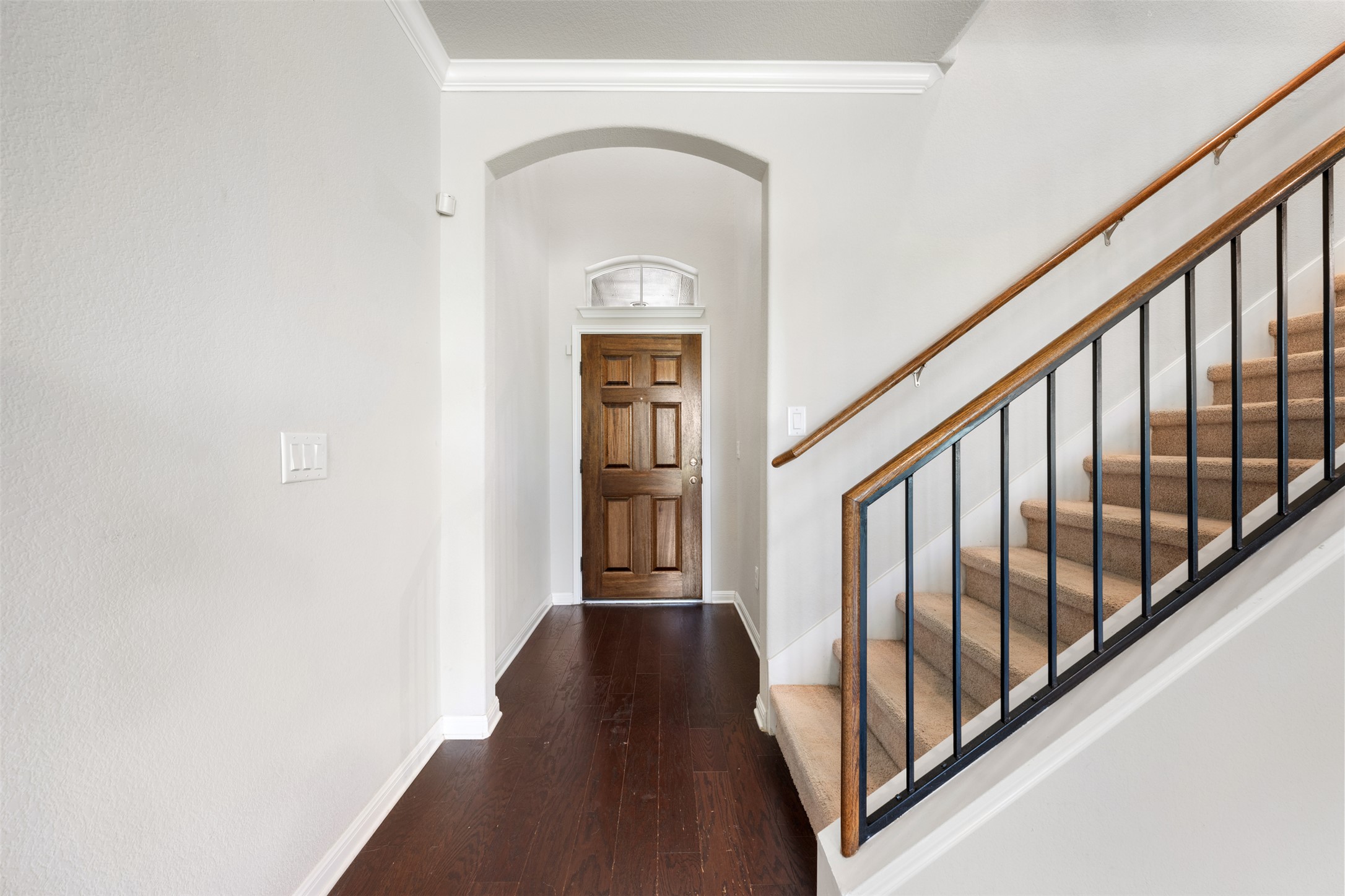 211 Parable Cove Pflugerville, TX 78660 - Photo 4 of 40 Entryway featuring rich wood-finish flooring, an arched doorway, and a multi-panel wooden door with an arched transom window
