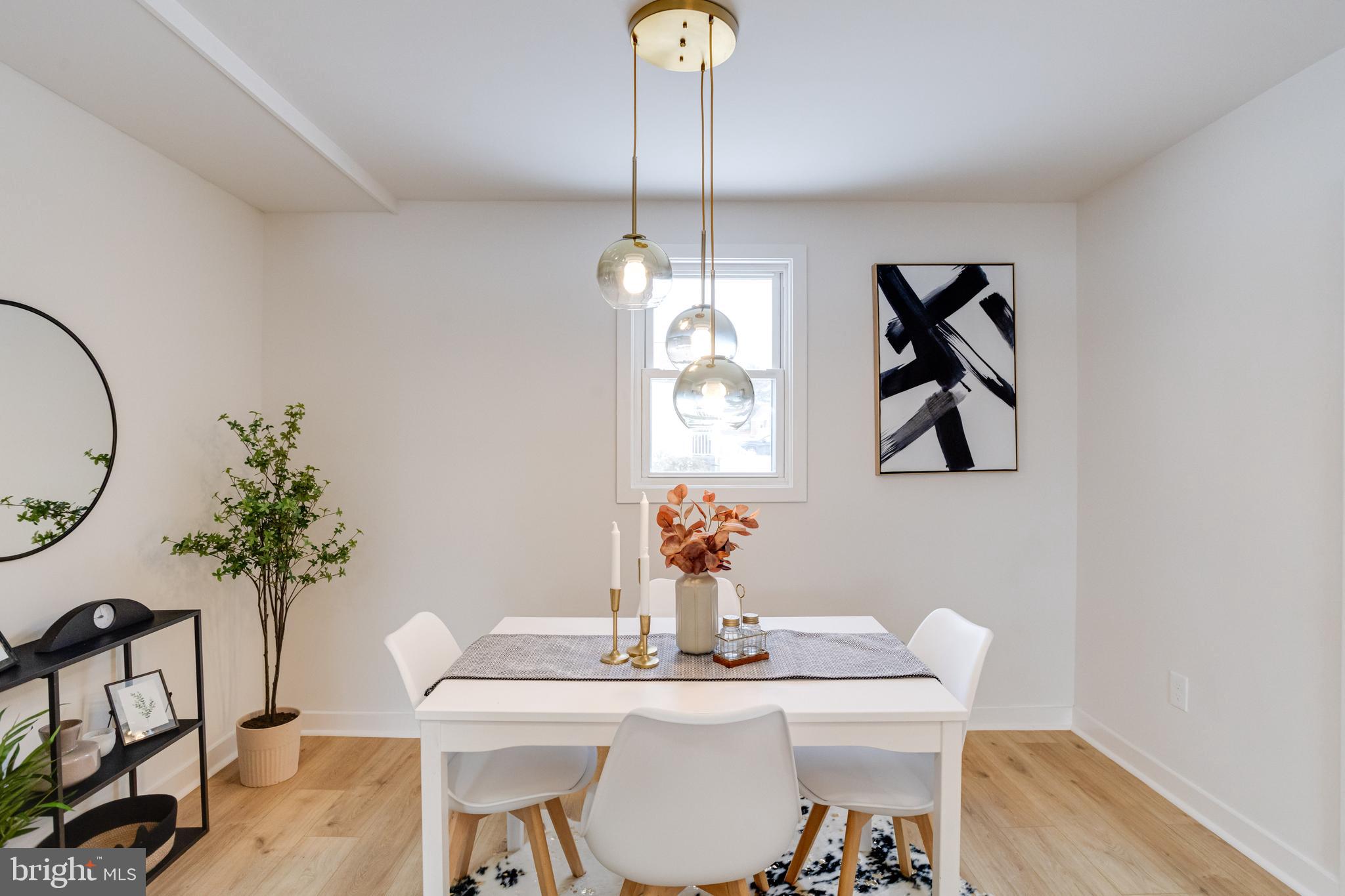 7606 Bagley Avenue Baltimore, MD 21234 - Photo 13 of 45 a dining room with furniture potted plants and wooden floor