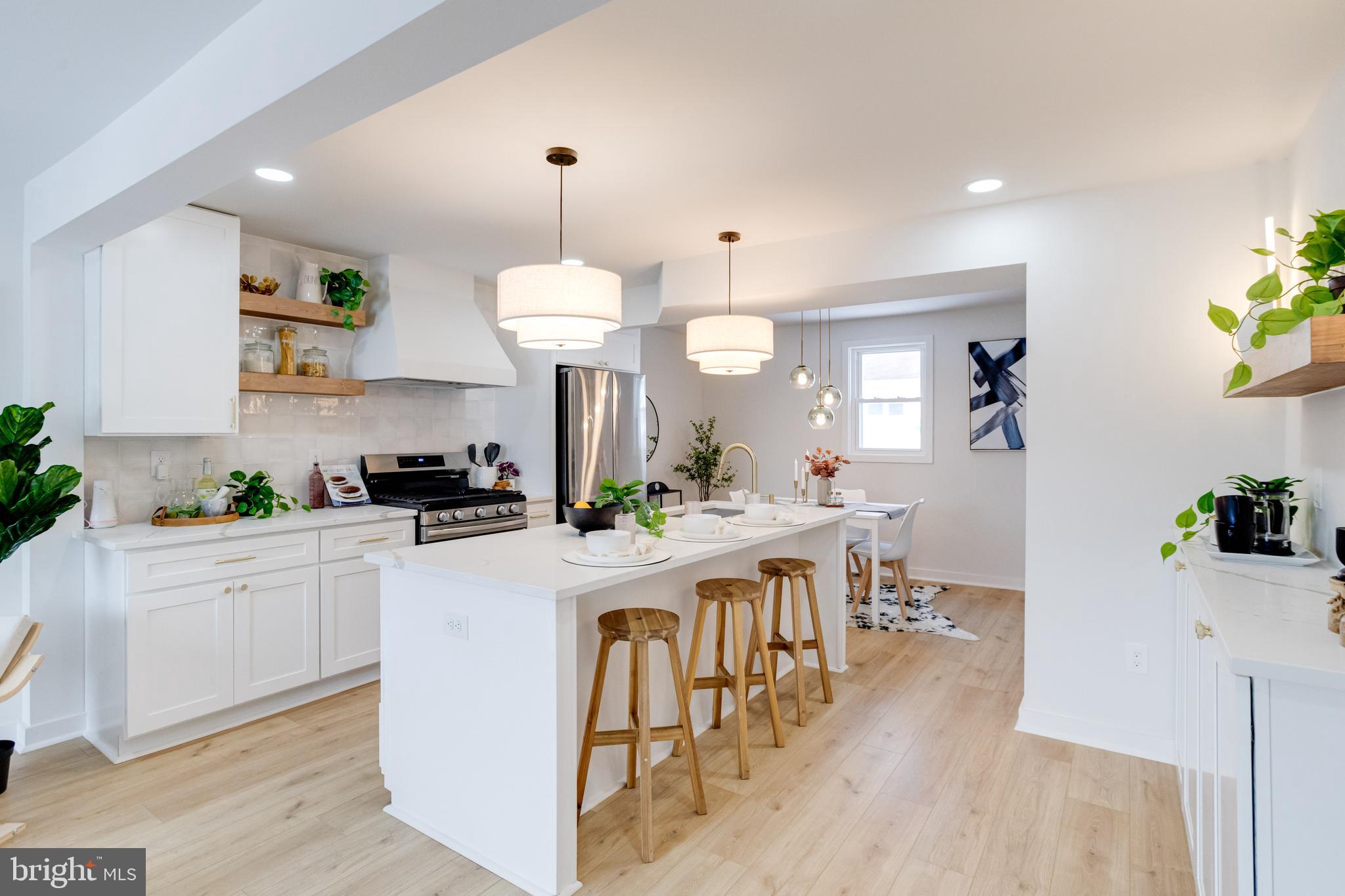 7606 Bagley Avenue Baltimore, MD 21234 - Photo 7 of 45 a kitchen with a dining table chairs stainless steel appliances and cabinets