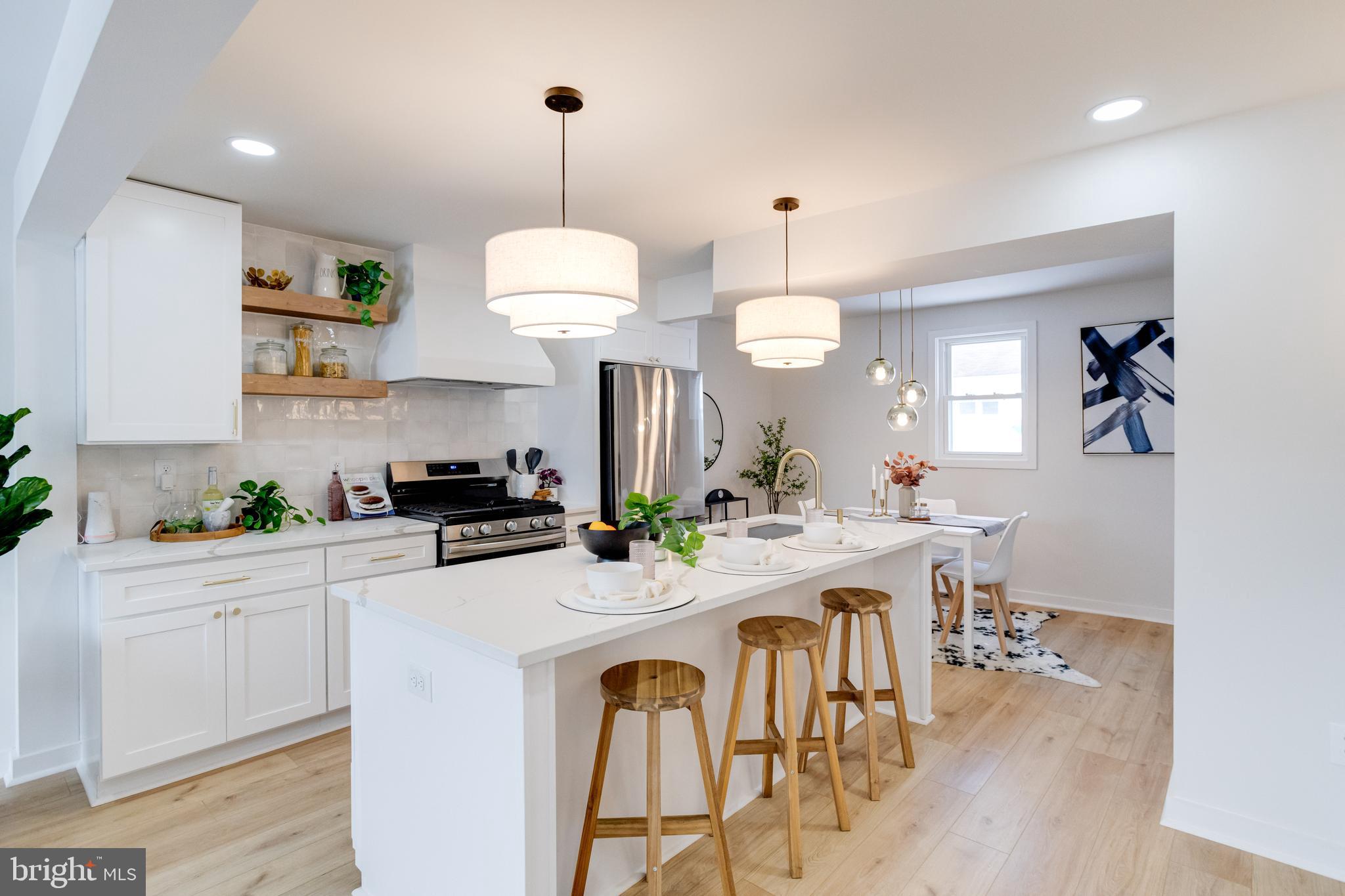 7606 Bagley Avenue Baltimore, MD 21234 - Photo 8 of 45 a kitchen with a dining table chairs sink and stove