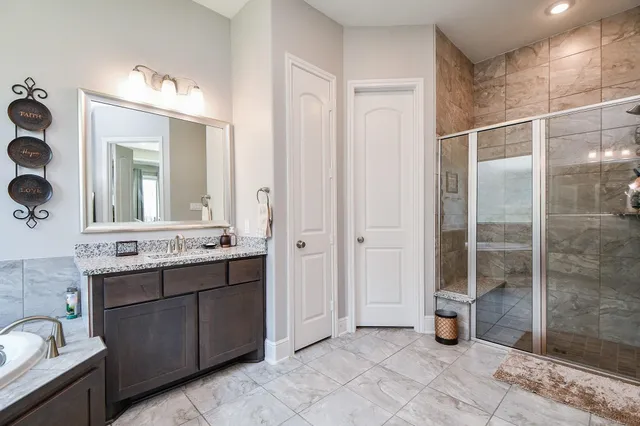 a bathroom with a double vanity sink mirror and shower