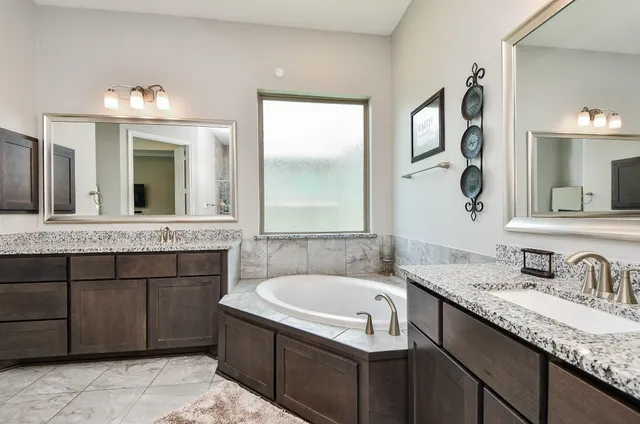 a bathroom with a tub sink and mirror