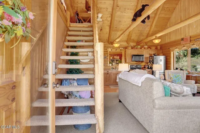 a living room with furniture a rug and white walls