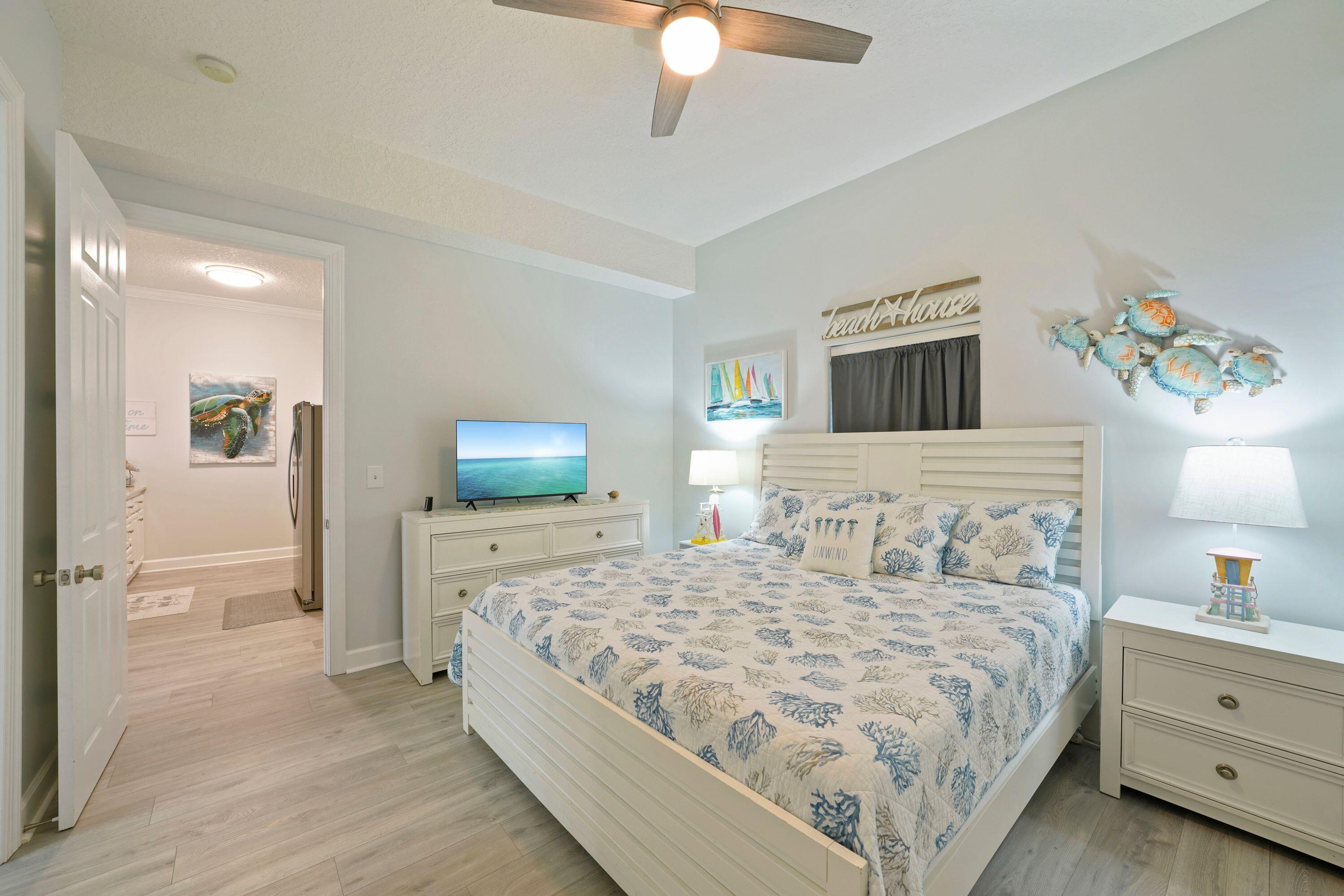 14415 Front Beach Road, Unit 2007 Panama City Beach, FL 32413 - Photo 13 of 26 a bedroom with a large bed and a chandelier