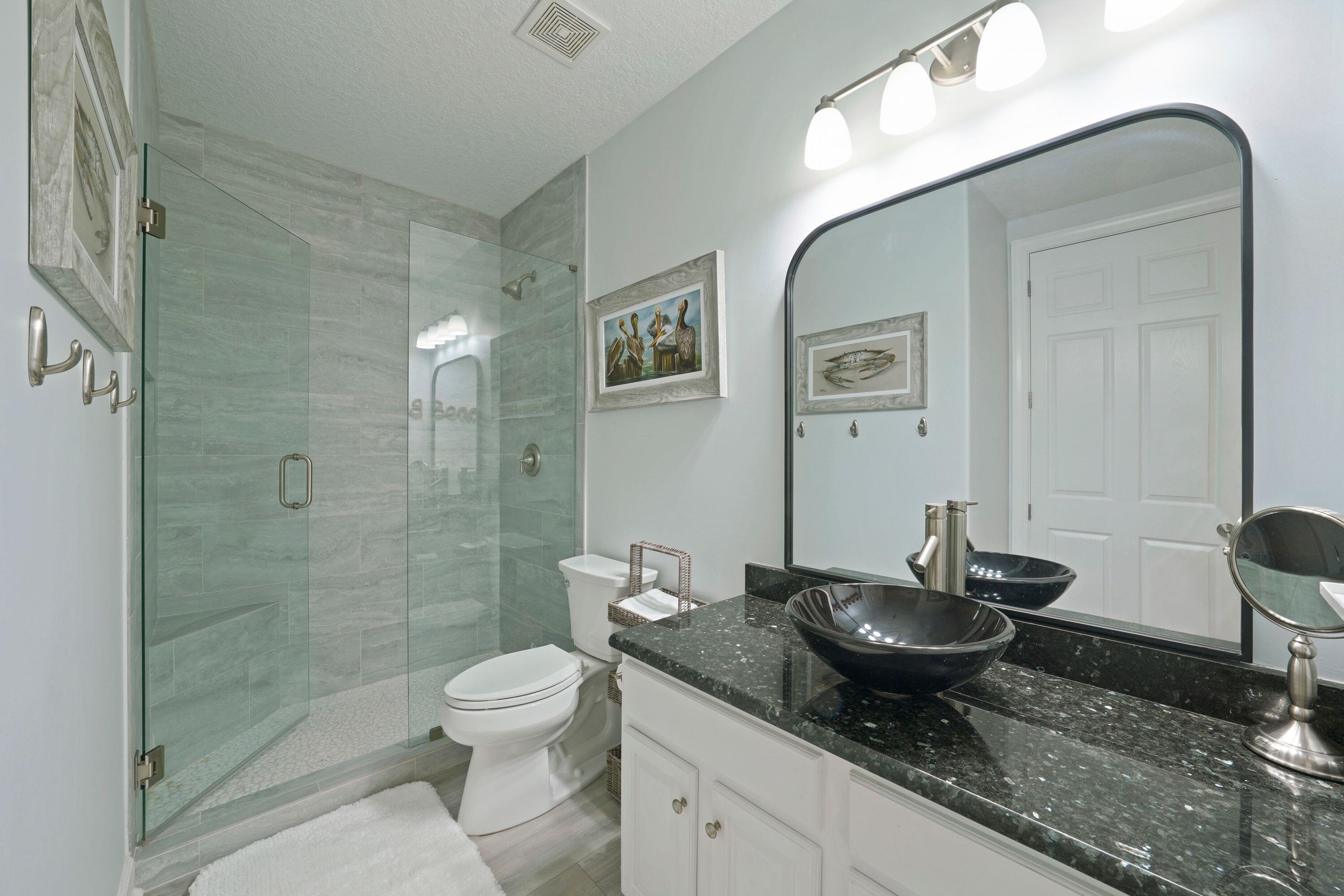 14415 Front Beach Road, Unit 2007 Panama City Beach, FL 32413 - Photo 16 of 26 a bathroom with a granite countertop sink toilet a mirror and shower