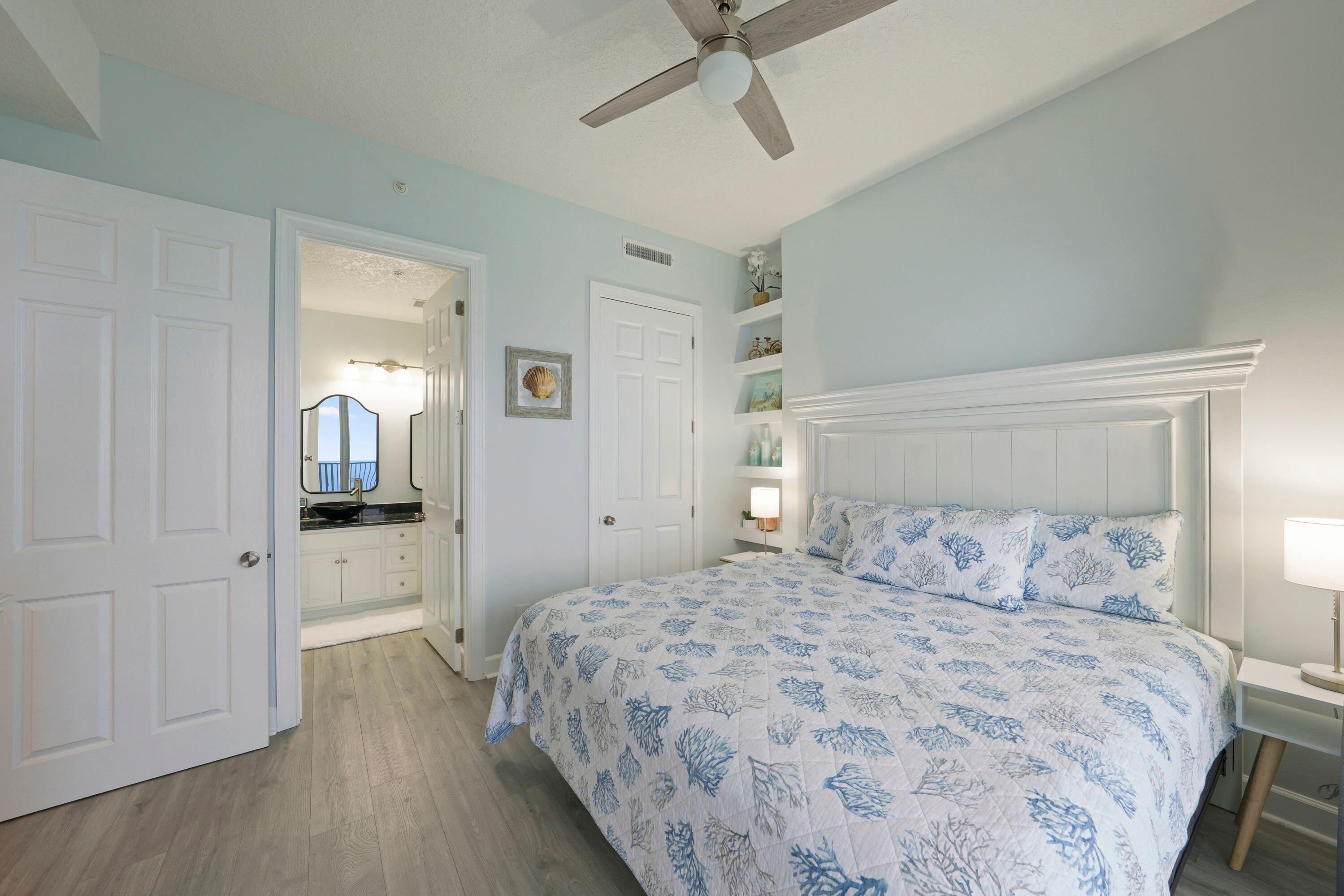 14415 Front Beach Road, Unit 2007 Panama City Beach, FL 32413 - Photo 19 of 26 a bedroom with a large bed and a chandelier