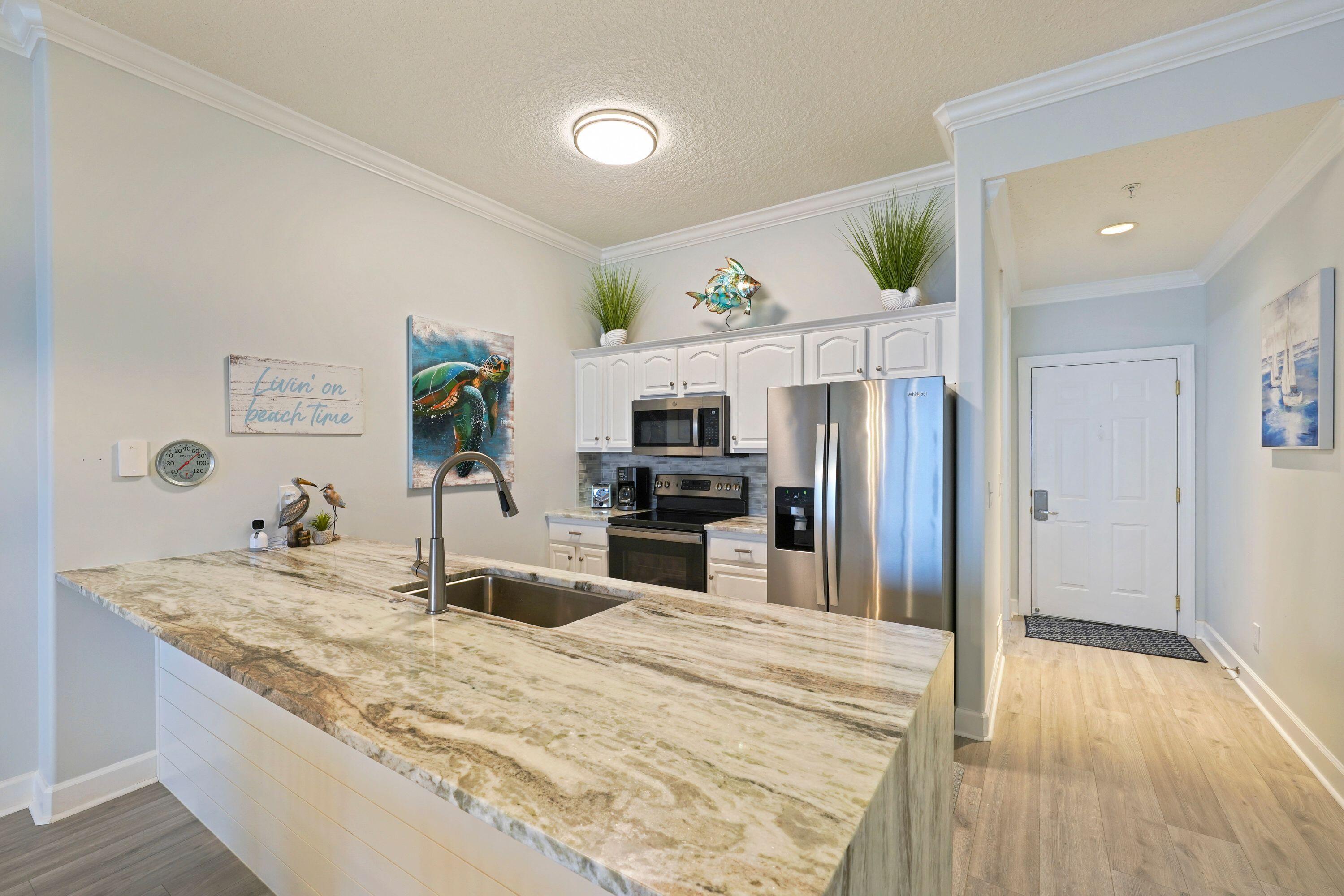 14415 Front Beach Road, Unit 2007 Panama City Beach, FL 32413 - Photo 9 of 26 a kitchen with granite countertop a refrigerator and a sink