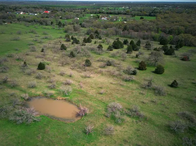 an aerial view of a houses with outdoor space and trees