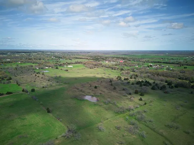 a view of a green field with lots of trees