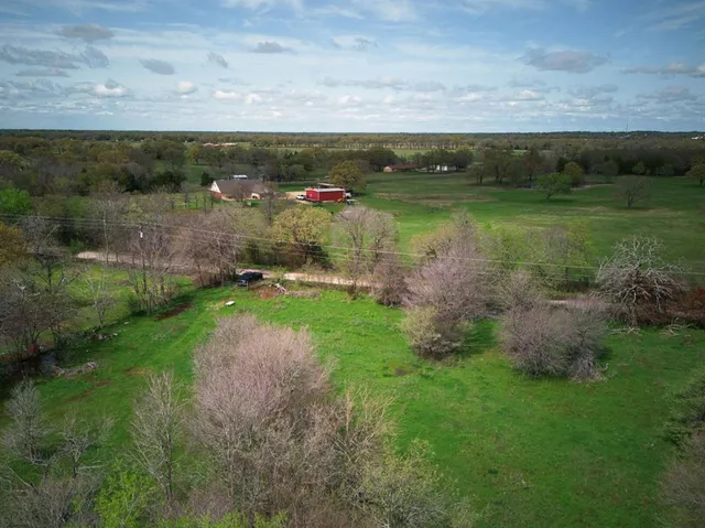 a view of a pathway both side of grassy field with shrub