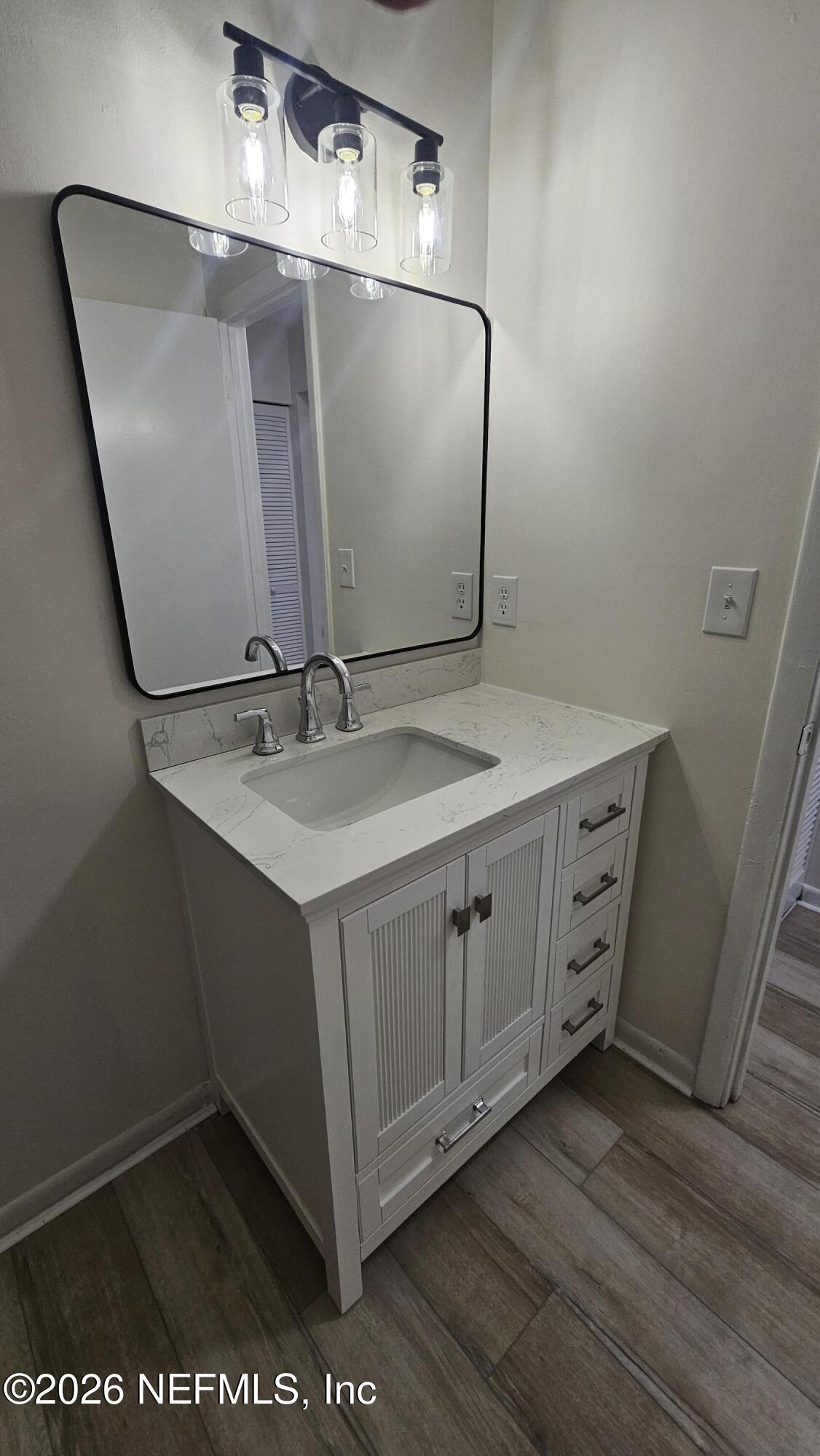 820 Orchid Street Atlantic Beach, FL 32233 - Photo 19 of 27 a bathroom with a sink and mirror