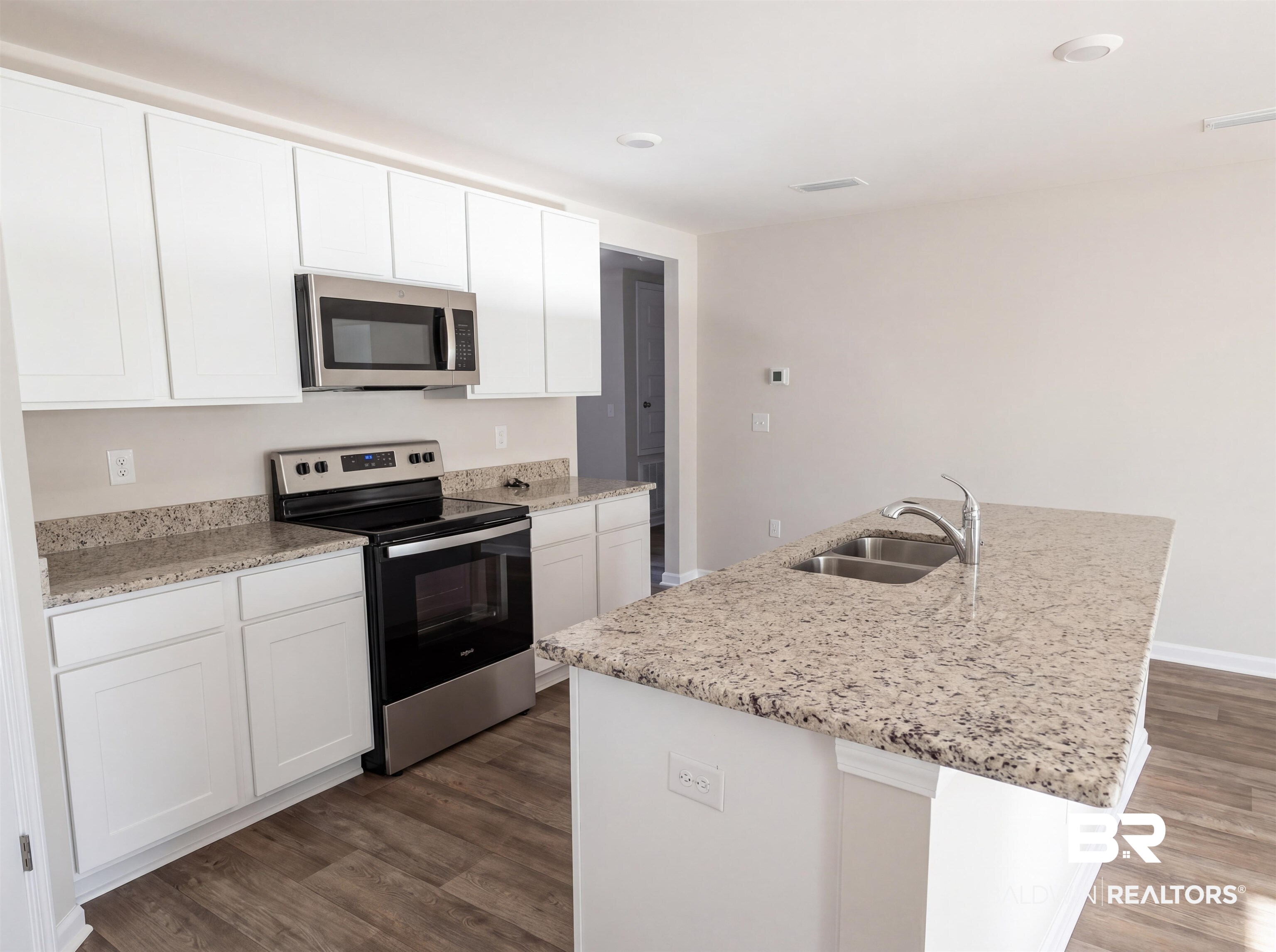 7453 Brompton Drive Foley, AL 36535 - Photo 8 of 15 Kitchen featuring white cabinetry, speckled countertops, stainless steel appliances, a double basin sink, and wood-finish flooring