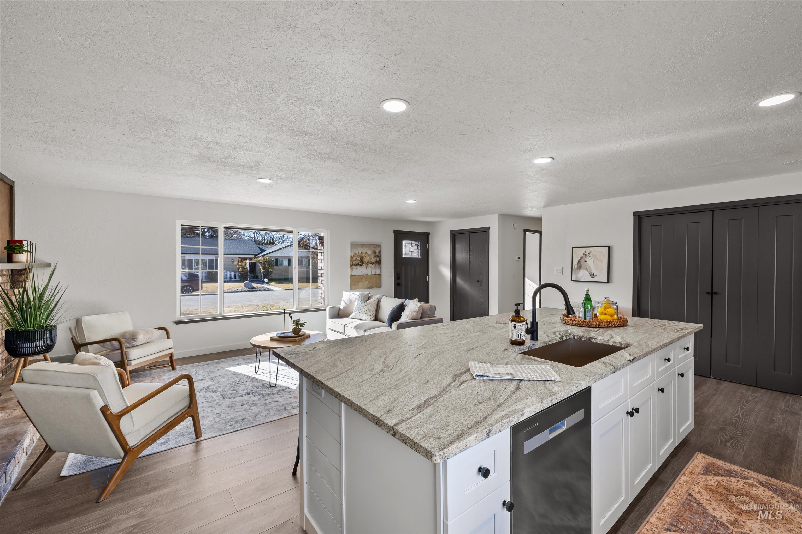 3154 South McCormick Way Boise, ID 83709 - Photo 50 of 50 Kitchen featuring open floor plan, white cabinetry, dishwashing machine, light stone counters, and dark wood-type flooring