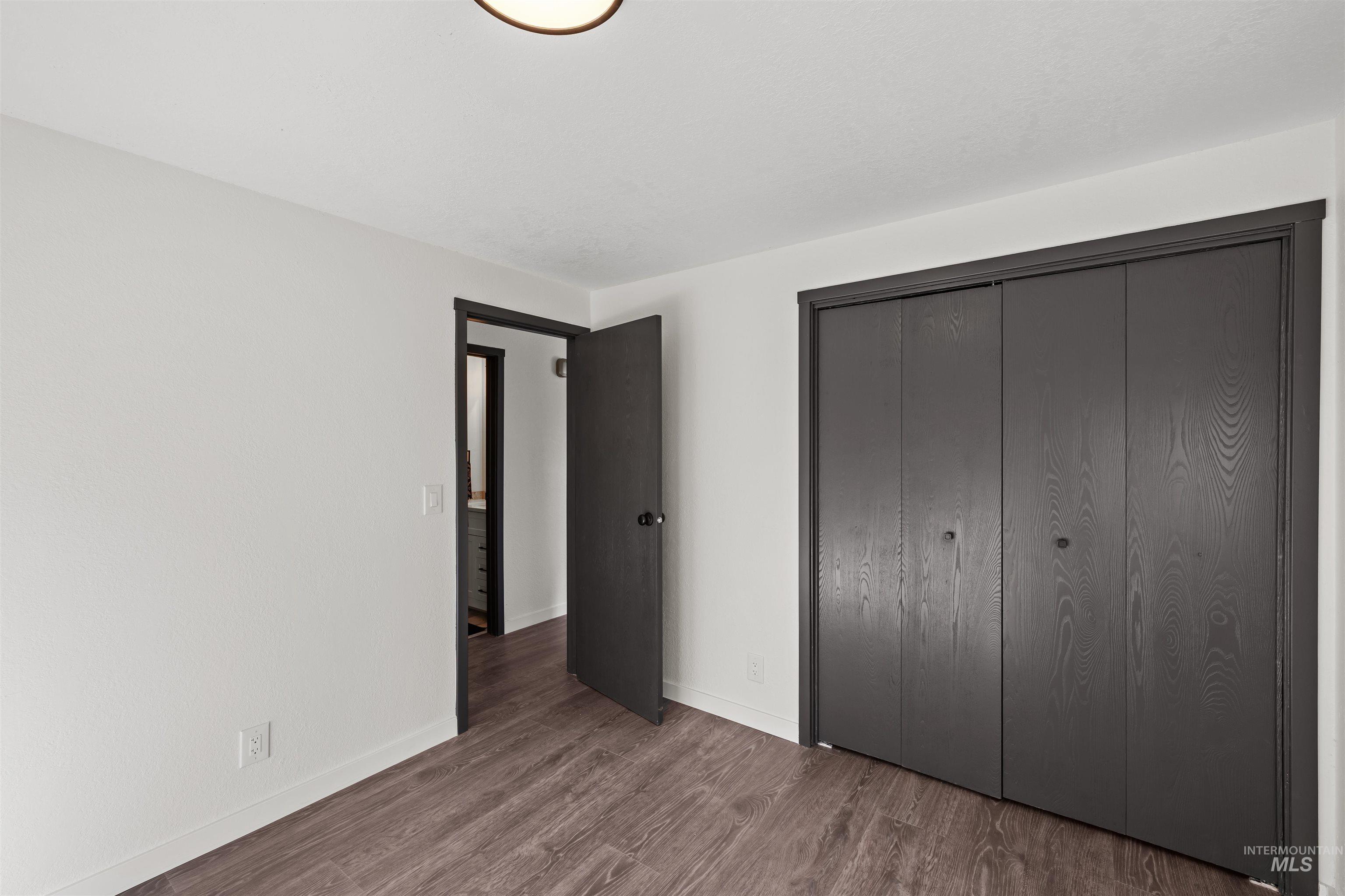 3154 South McCormick Way Boise, ID 83709 - Photo 19 of 50 Unfurnished bedroom featuring dark wood finished floors and a closet