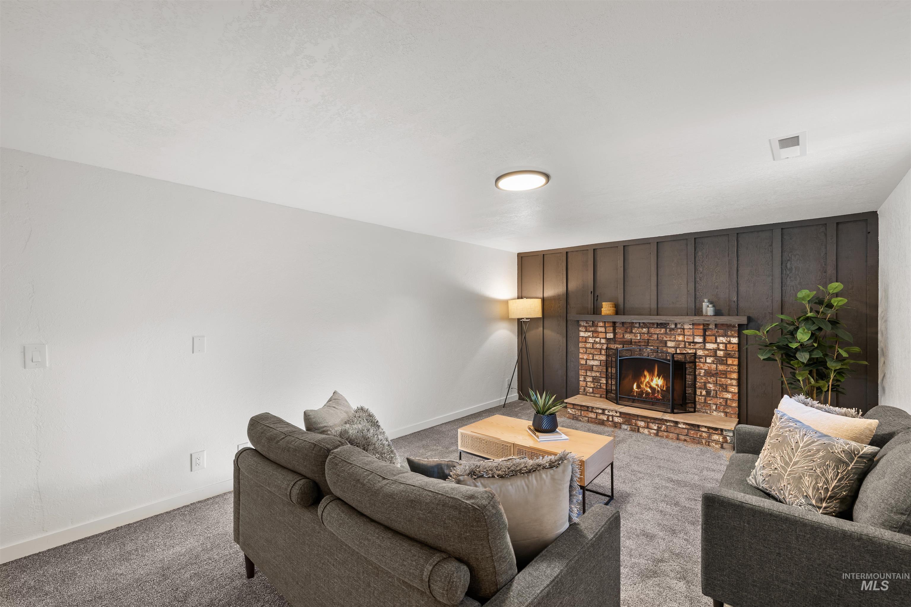 3154 South McCormick Way Boise, ID 83709 - Photo 23 of 50 Living room with a brick fireplace, carpet, and wood walls