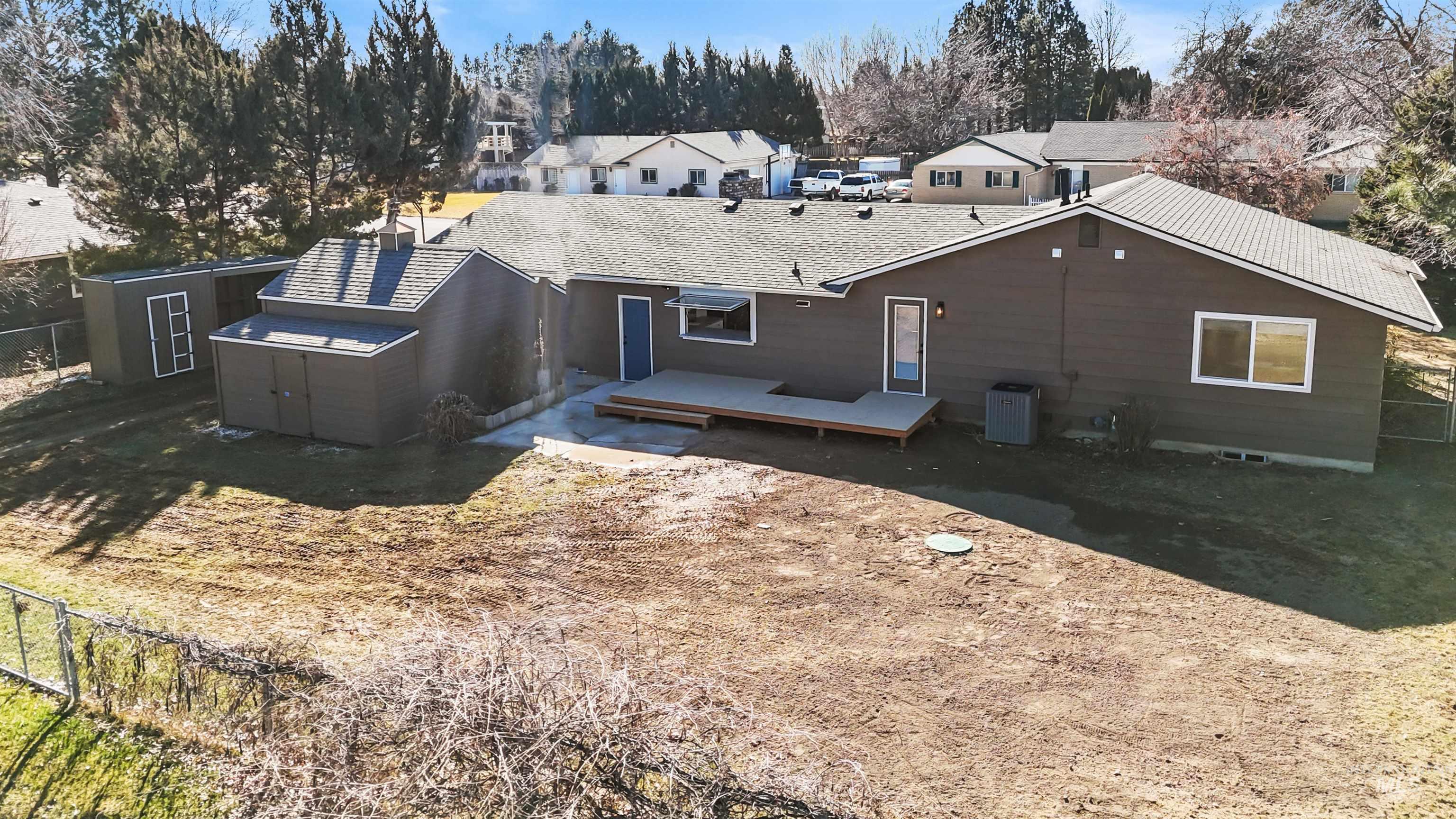 3154 South McCormick Way Boise, ID 83709 - Photo 35 of 50 Rear view of house featuring a storage unit, a deck, a shingled roof, and a residential view
