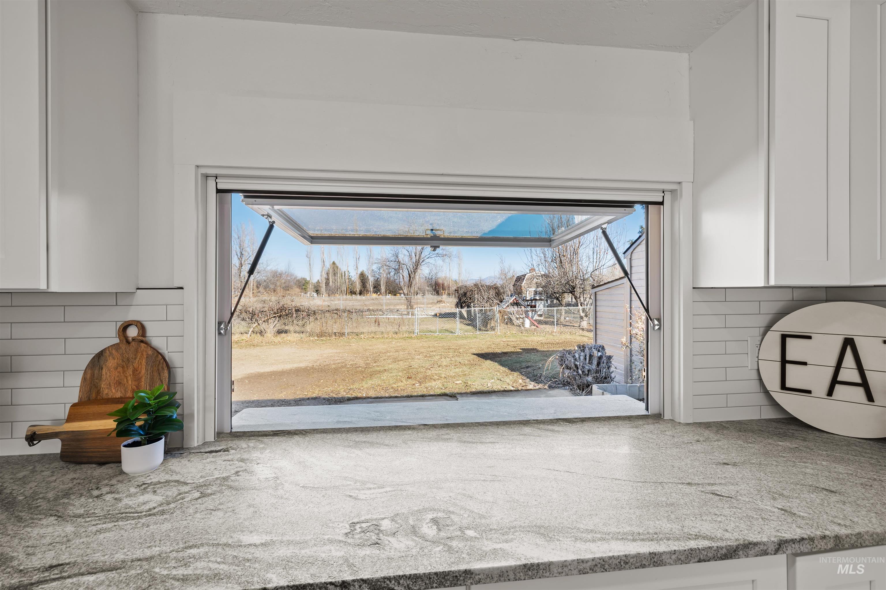 3154 South McCormick Way Boise, ID 83709 - Photo 8 of 50 Kitchen view of white cabinets, tasteful backsplash, and light stone counters