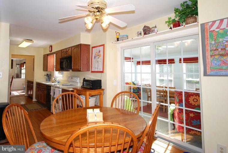 4416 Rendale Court Olney, MD 20832 - Photo 7 of 28 a view of a dining room with furniture a kitchen and chandelier