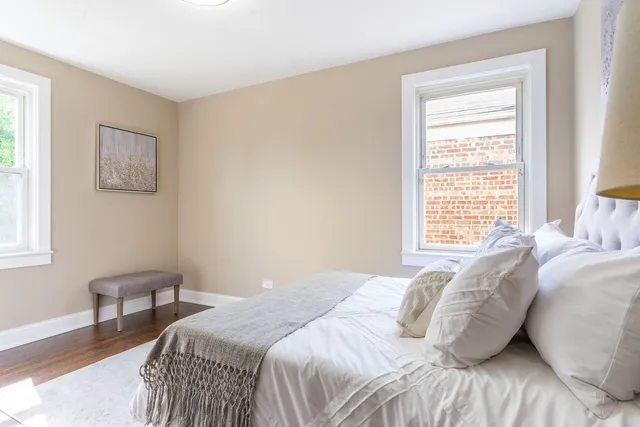 a bedroom with a bed a couch and windows