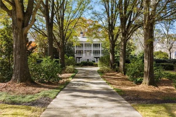 an aerial view of a house with a yard and a large tree