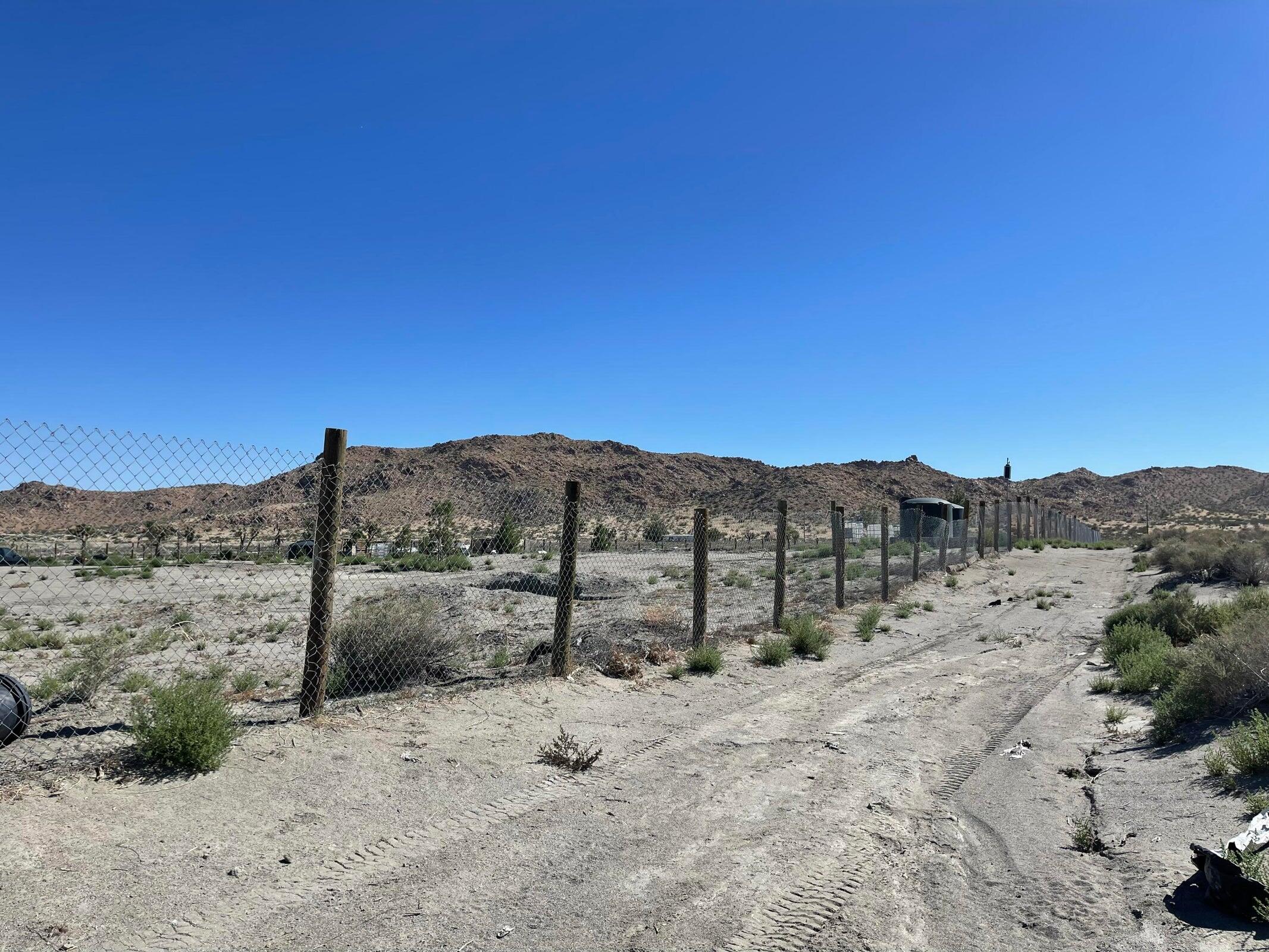20025 Chamisal Street Adelanto, CA 92301 - Photo 32 of 46 a view of a dry yard with a tree