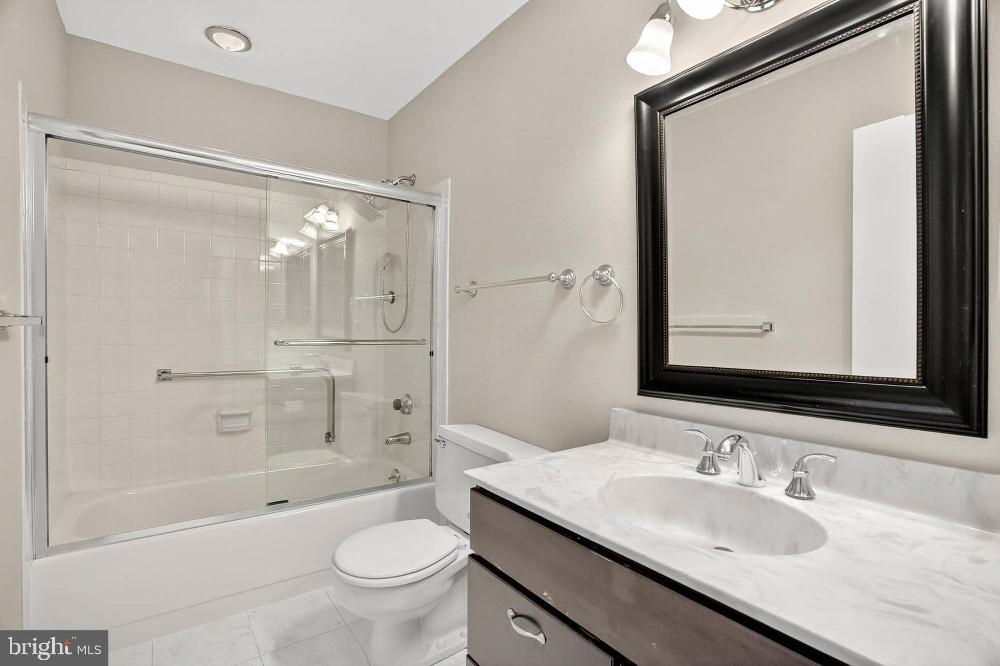 3416 Island Creek Court, Unit 127C Silver Spring, MD 20906 - Photo 26 of 60 a bathroom with a granite countertop sink a toilet a mirror and shower