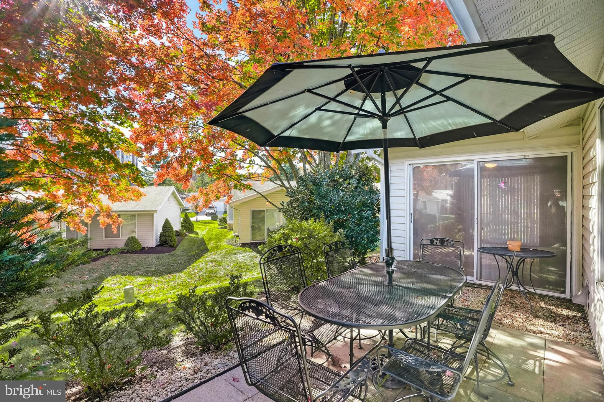 3416 Island Creek Court, Unit 127C Silver Spring, MD 20906 - Photo 29 of 60 a backyard of a house with table and chairs under an umbrella