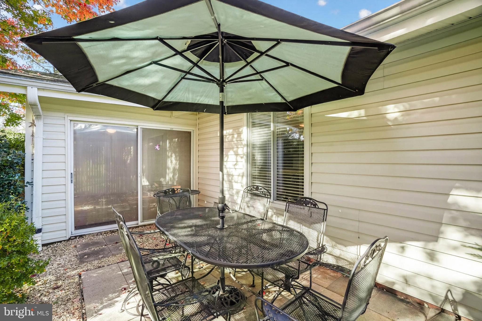 3416 Island Creek Court, Unit 127C Silver Spring, MD 20906 - Photo 30 of 60 a patio with a table and chairs under an umbrella