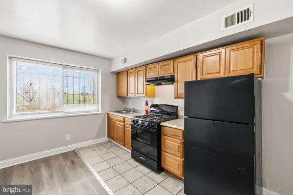 a kitchen with stainless steel appliances granite countertop a refrigerator a stove a sink and a window