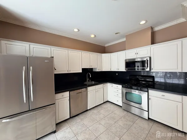a kitchen with stainless steel appliances a sink a stove a microwave and cabinets